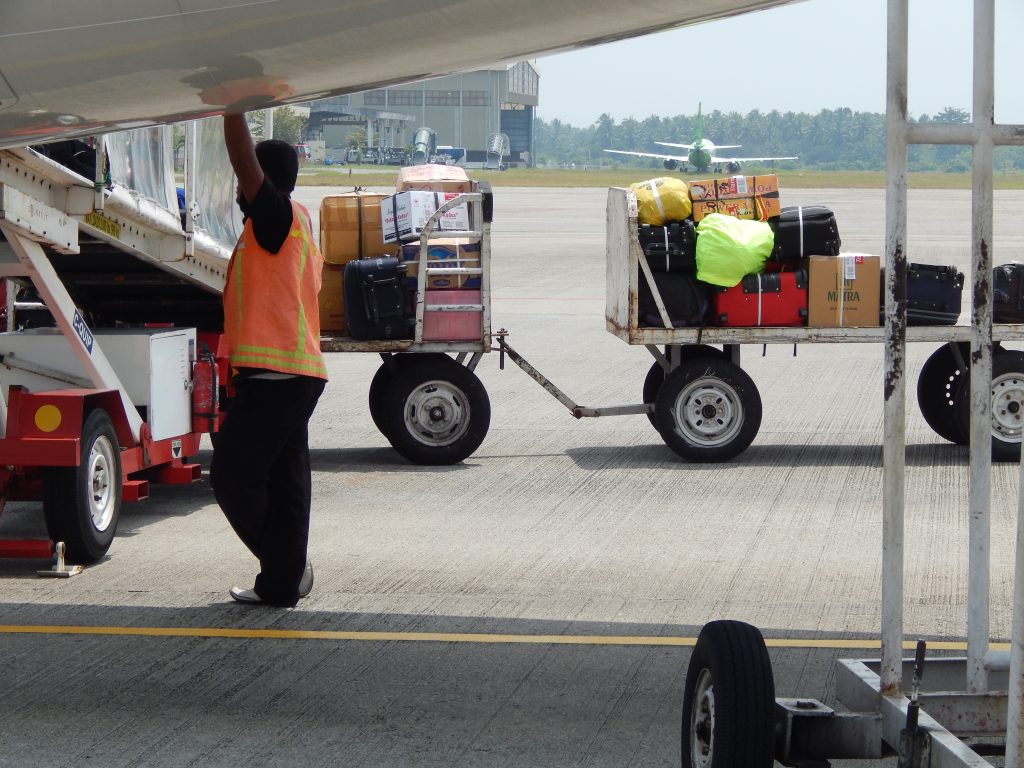 Employee loading the airplane with trunks and bags at Minangkabau international airport