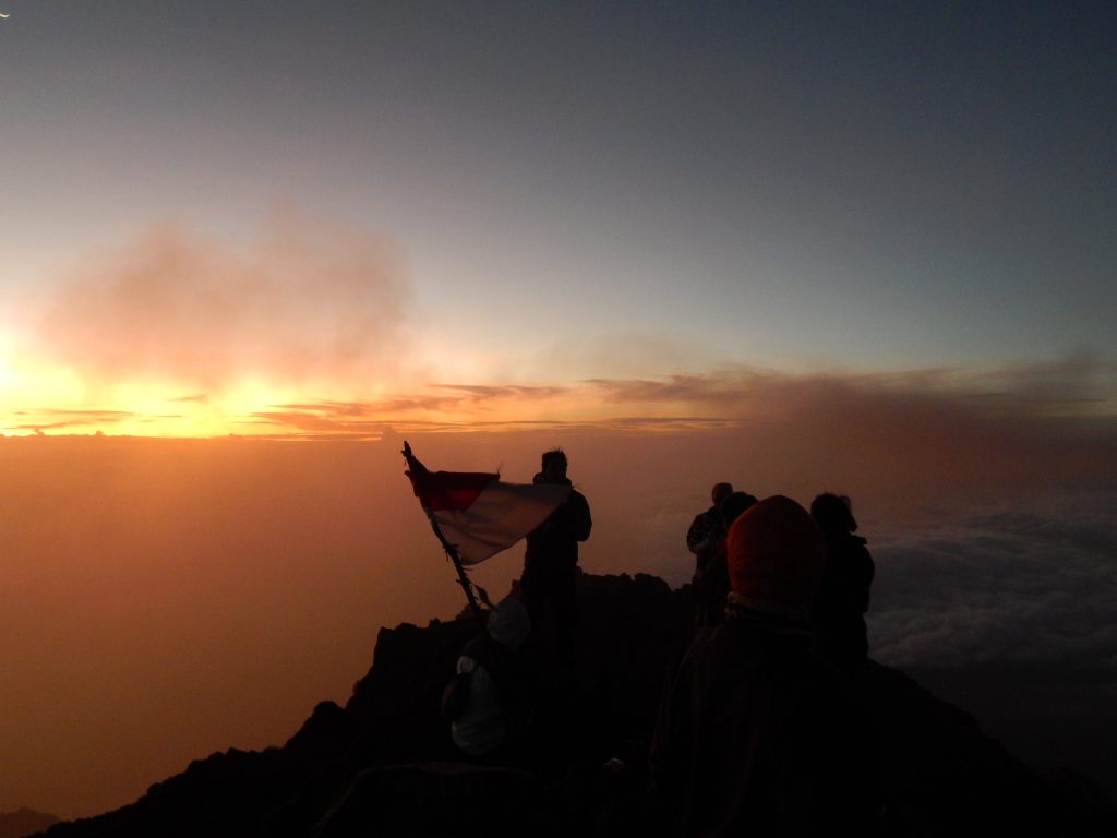 A group of Indonesian students with a Indonesian flag on top of Gunung Kerinci