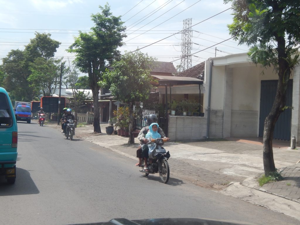 Children with parents on moped in Malang, Indonesia